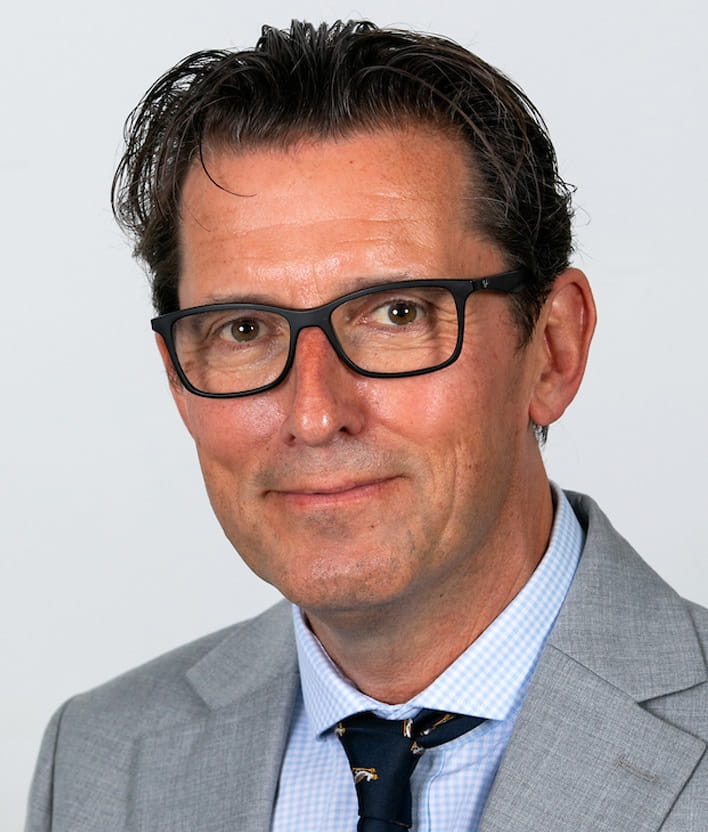 headshot of Ian Loftus wearing a grey suit against a white background